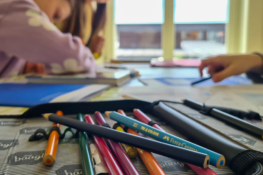 Hort der Schule Malans (Graubünden) Malstifte und Kinder im Hintergrund, die im Hort Zeit verbringen